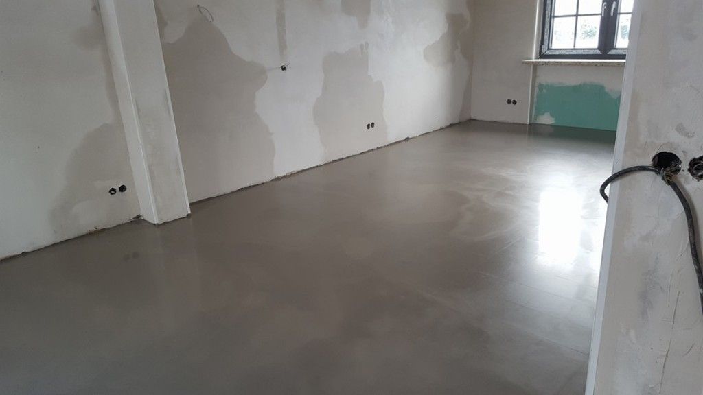 Ein Raum mit Betonboden und weißen Wänden.