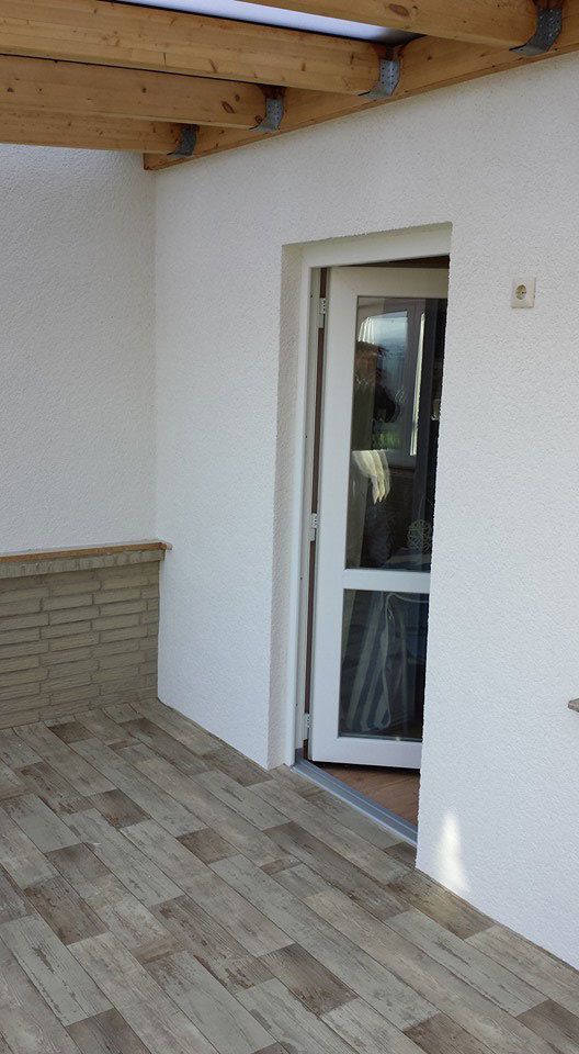 Eine weiße Wand mit einer Glasschiebetür und einem Holzboden.