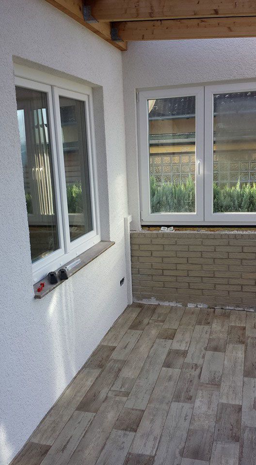 Ein Raum mit einer Ziegelwand, einem gefliesten Boden und einem Fenster.