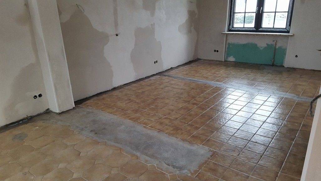 Ein Raum mit gefliestem Boden und Fenster.