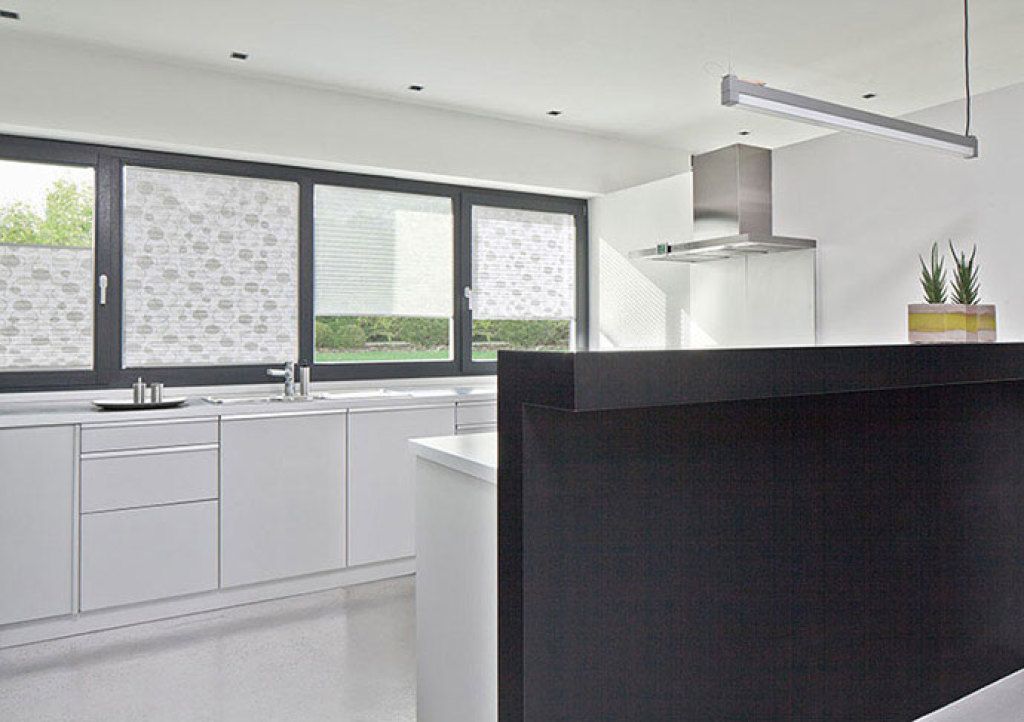 Eine Küche mit weißen Schränken und einer schwarzen Arbeitsplatte