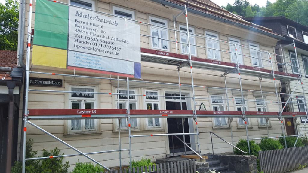 Ein großes Gebäude mit Gerüst darum wird gestrichen.