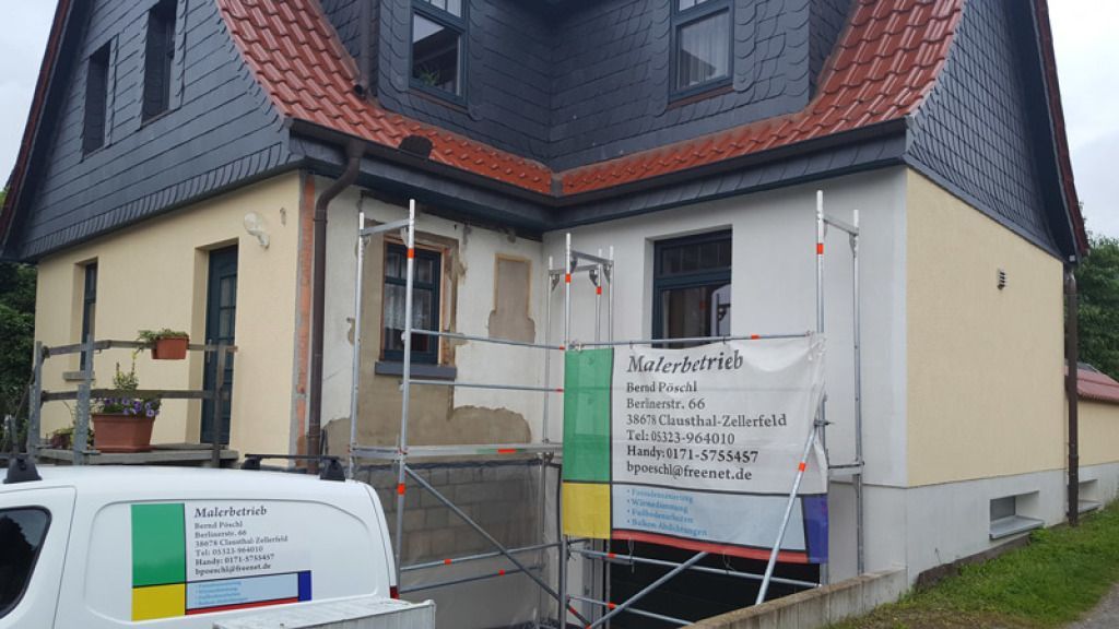 Ein weißer Lieferwagen parkt vor einem Haus, das gerade gestrichen wird.