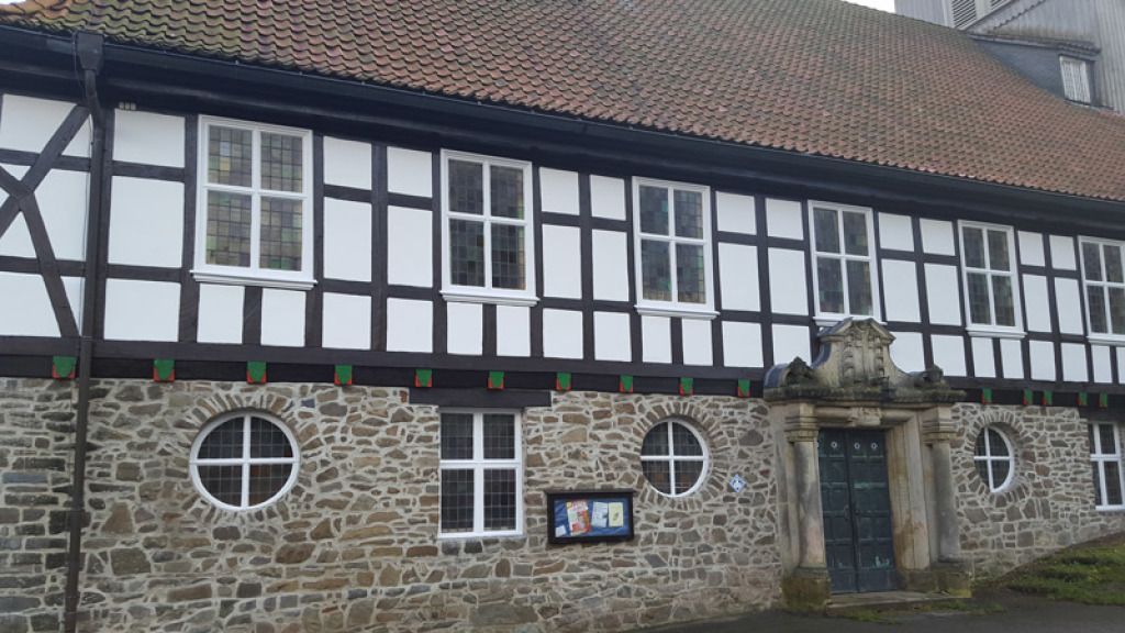 Ein großes Steingebäude mit Holzrahmen und Ziegeldach.