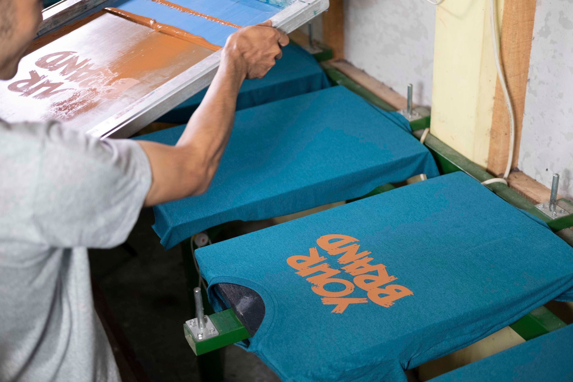 Ein Mann bedruckt in einer Fabrik T-Shirts.