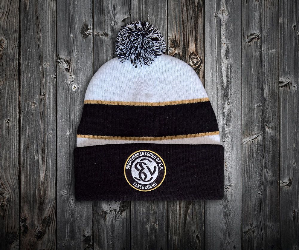 Eine schwarz-weiße Mütze liegt auf einem Holztisch