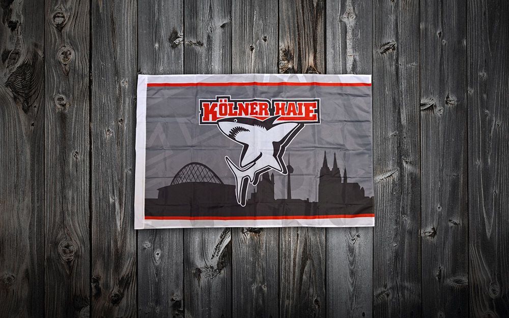 An einer Holzwand hängt eine Flagge.