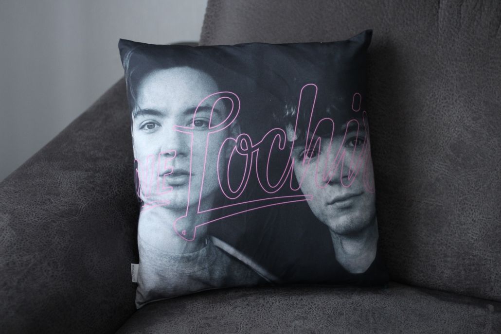 Auf einem Sofa liegt ein Kissen mit zwei Gesichtern darauf.