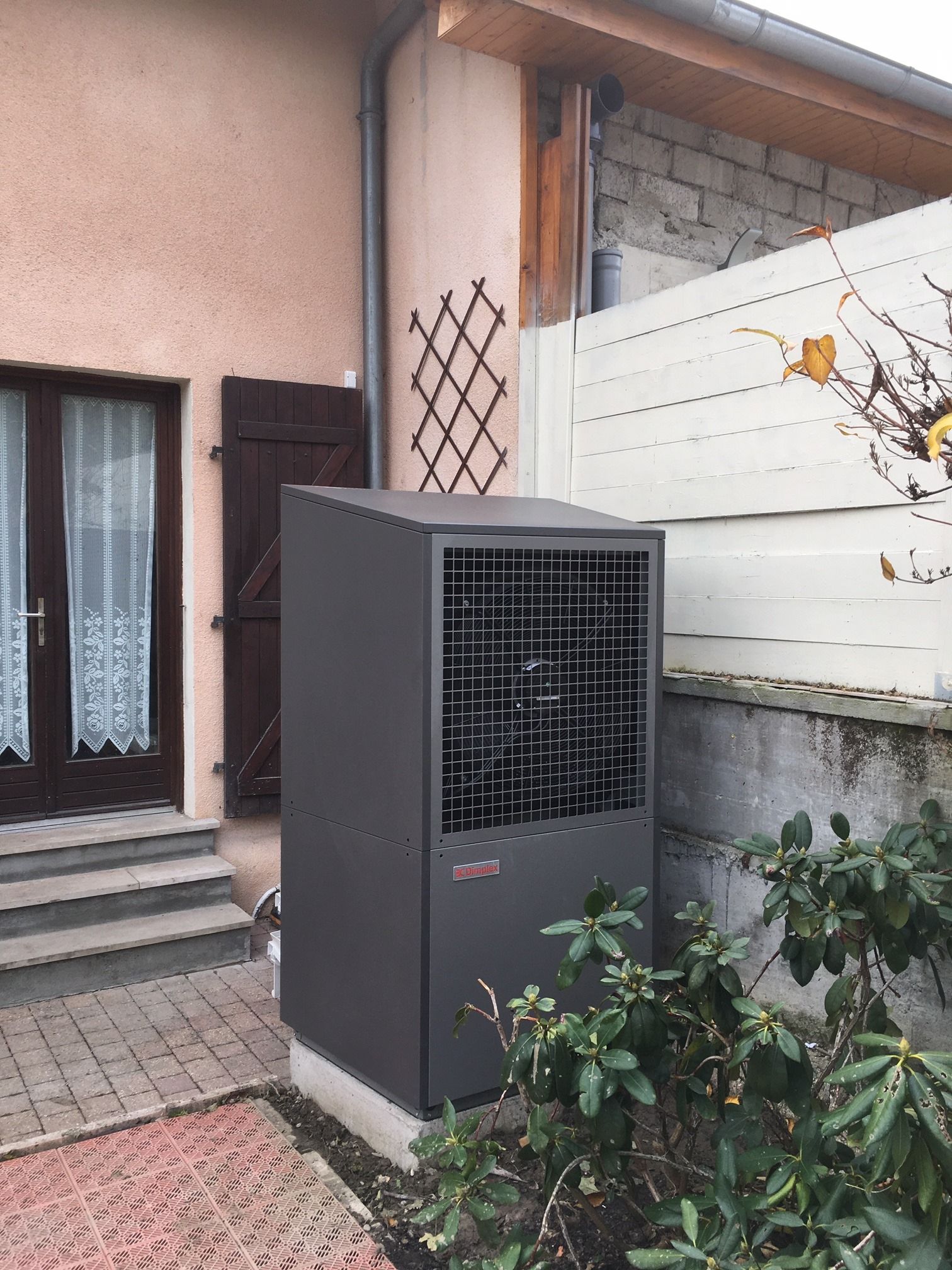 Pompe à chaleur esthétique en métal anthracite installée dans un jardin