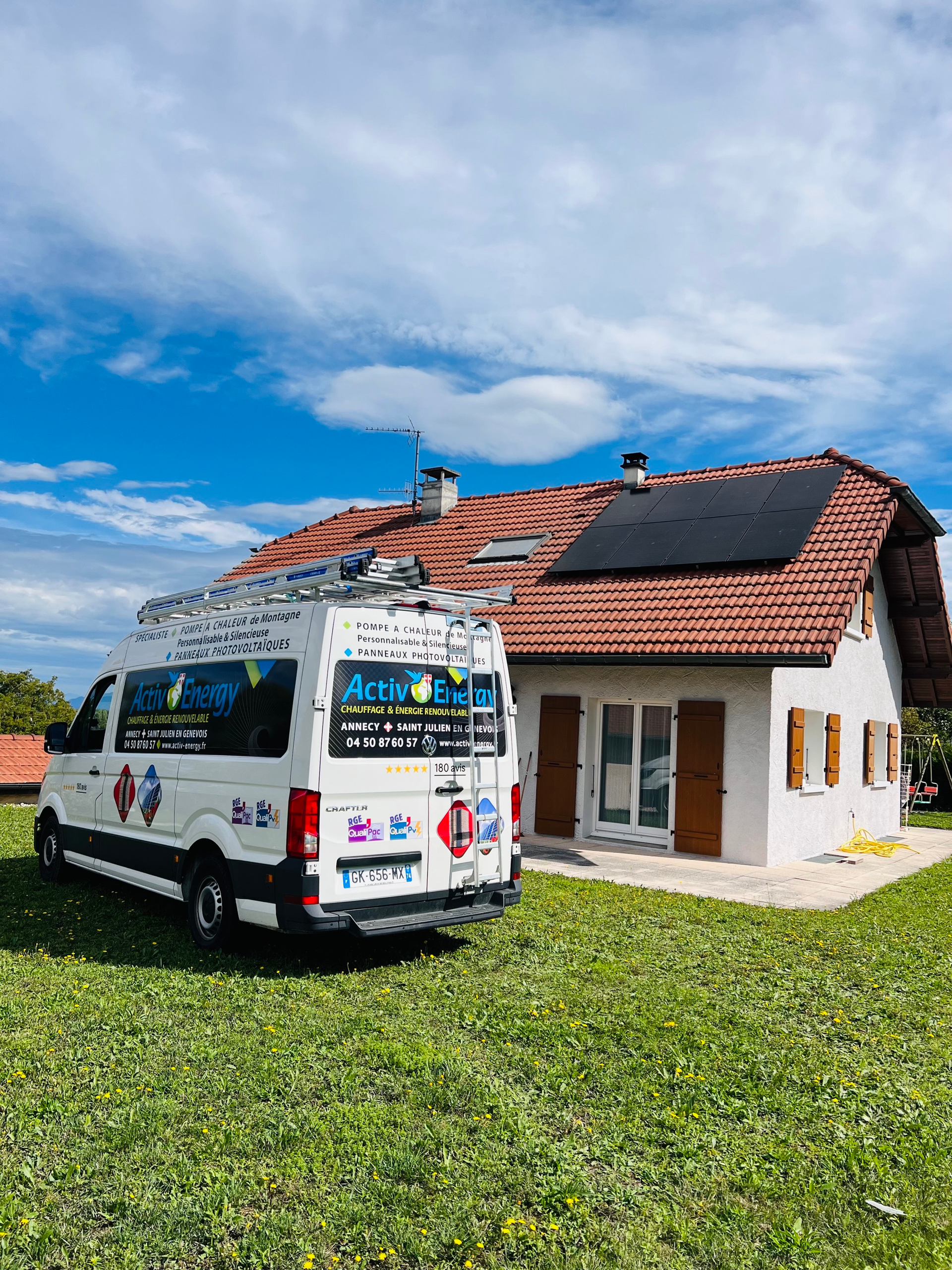 Véhicule de l'entreprise garée devant une maison avec panneaux solaires