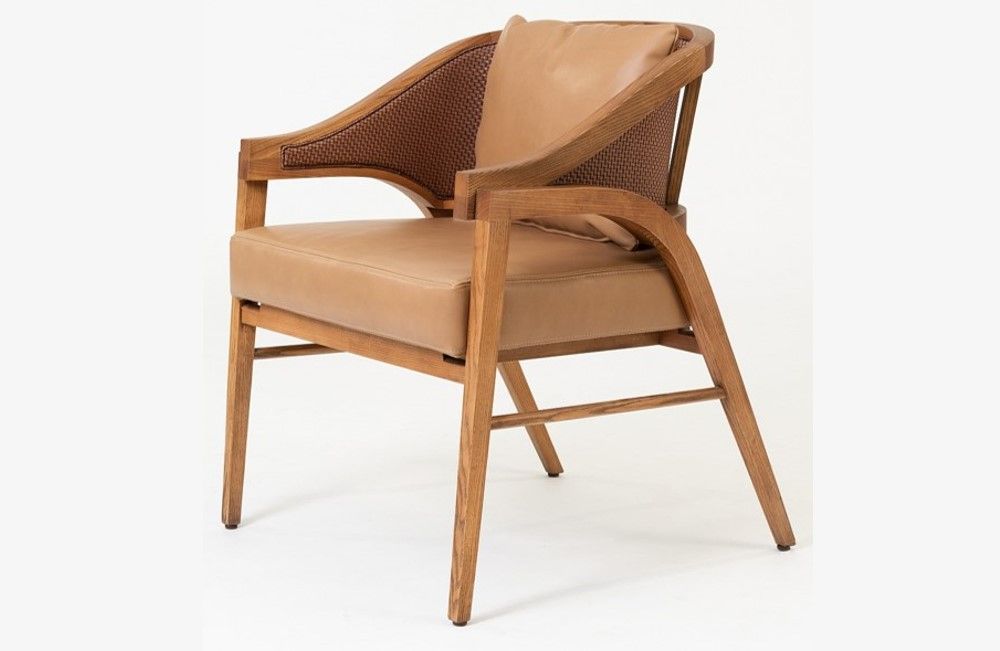 Una silla de madera con asiento y respaldo de cuero sobre un fondo blanco.