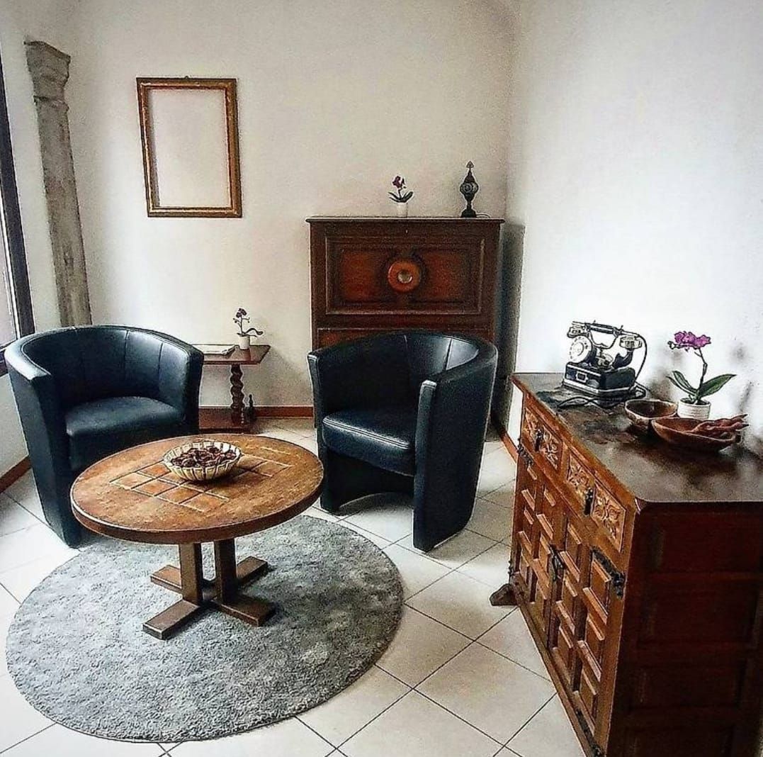 Donna che riceve un massaggio, le mani del terapista sulla fronte e sul petto. Biancheria bianca, ambiente neutro.