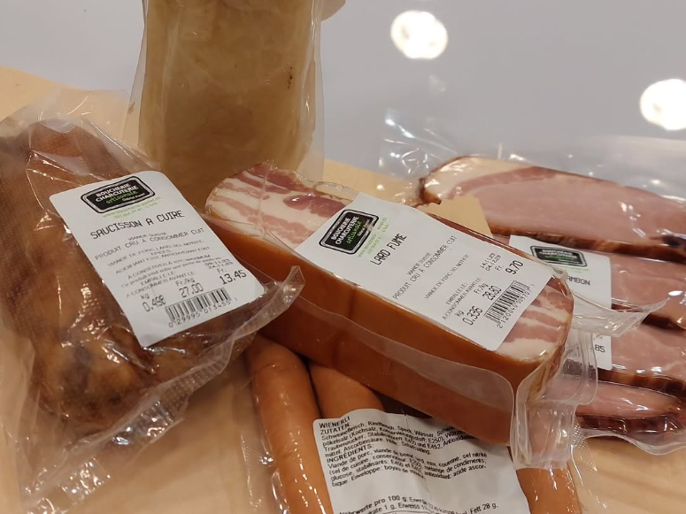 Une personne tient un paquet de bœuf haché dans une épicerie.