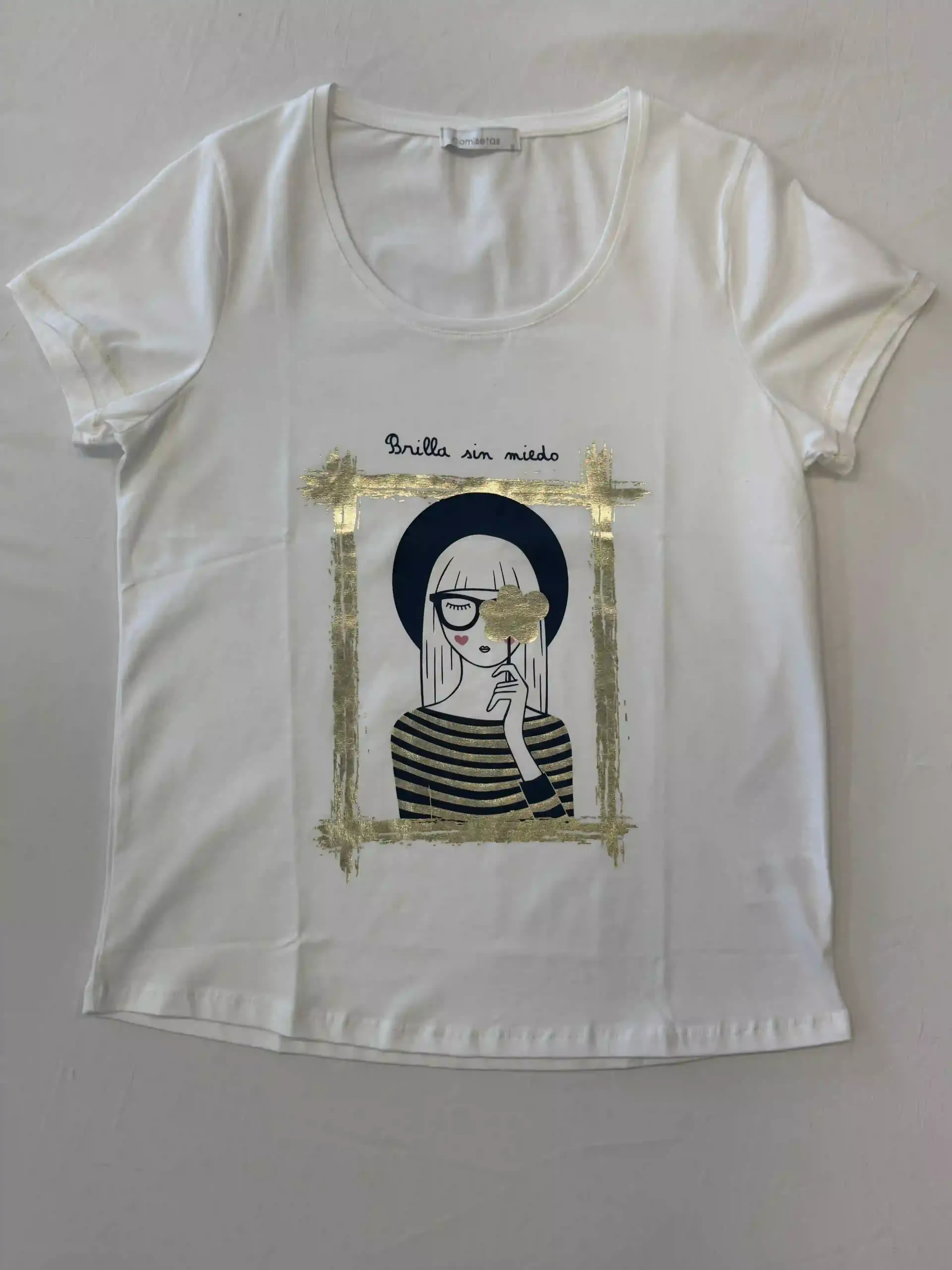 Camiseta blanca con un gráfico enmarcado en blanco y negro de una mujer y un pequeño texto encima.