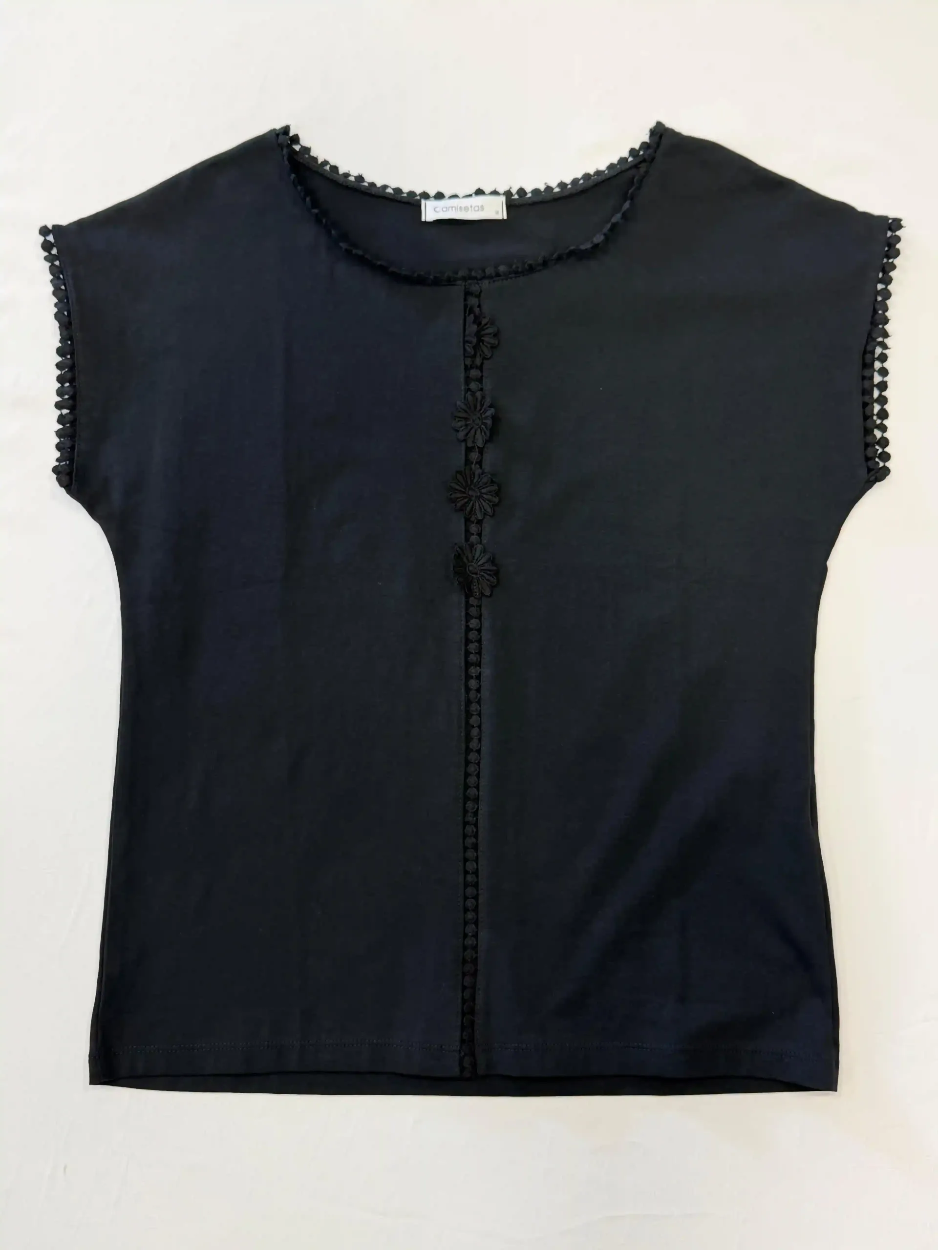 Blusa negra sin mangas con escote festoneado y detalle de botones en la parte delantera sobre fondo blanco.