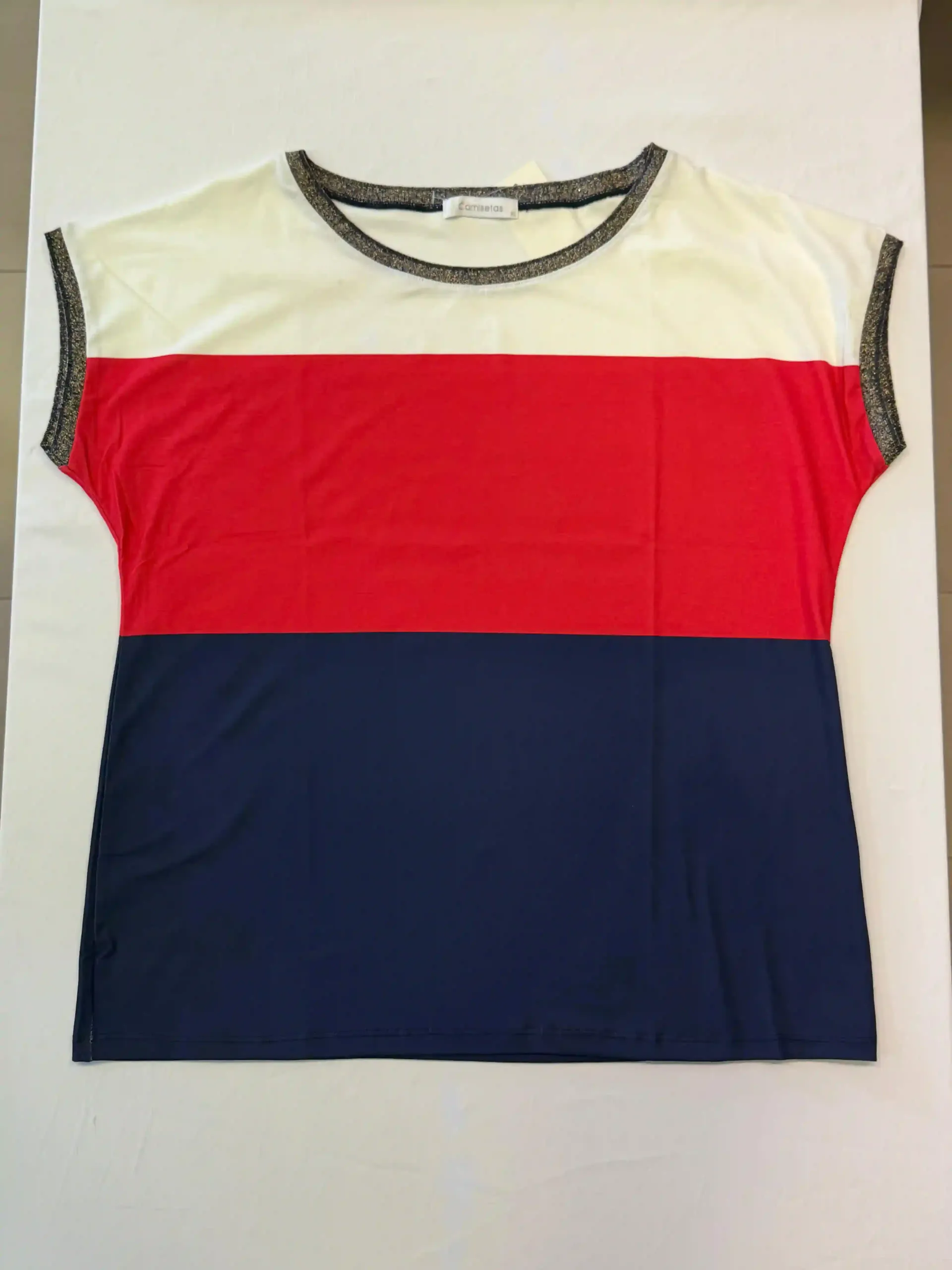 Camiseta de manga corta con bloques de color y rayas blancas, rojas y azul marino sobre un fondo liso.