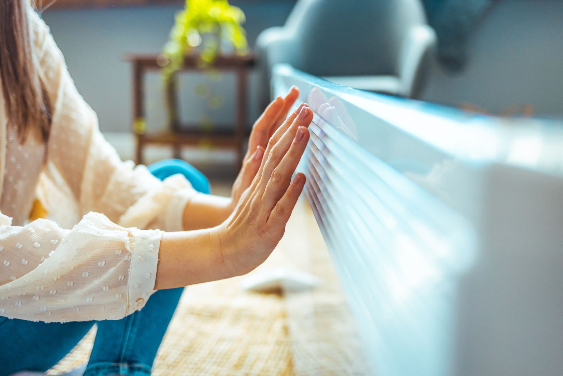 Une femme qui se chauffe les mains devant un radiateur