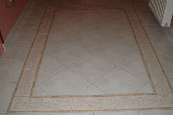 Carrelage avec motifs et bordures pour donner l'impression d'un tapis