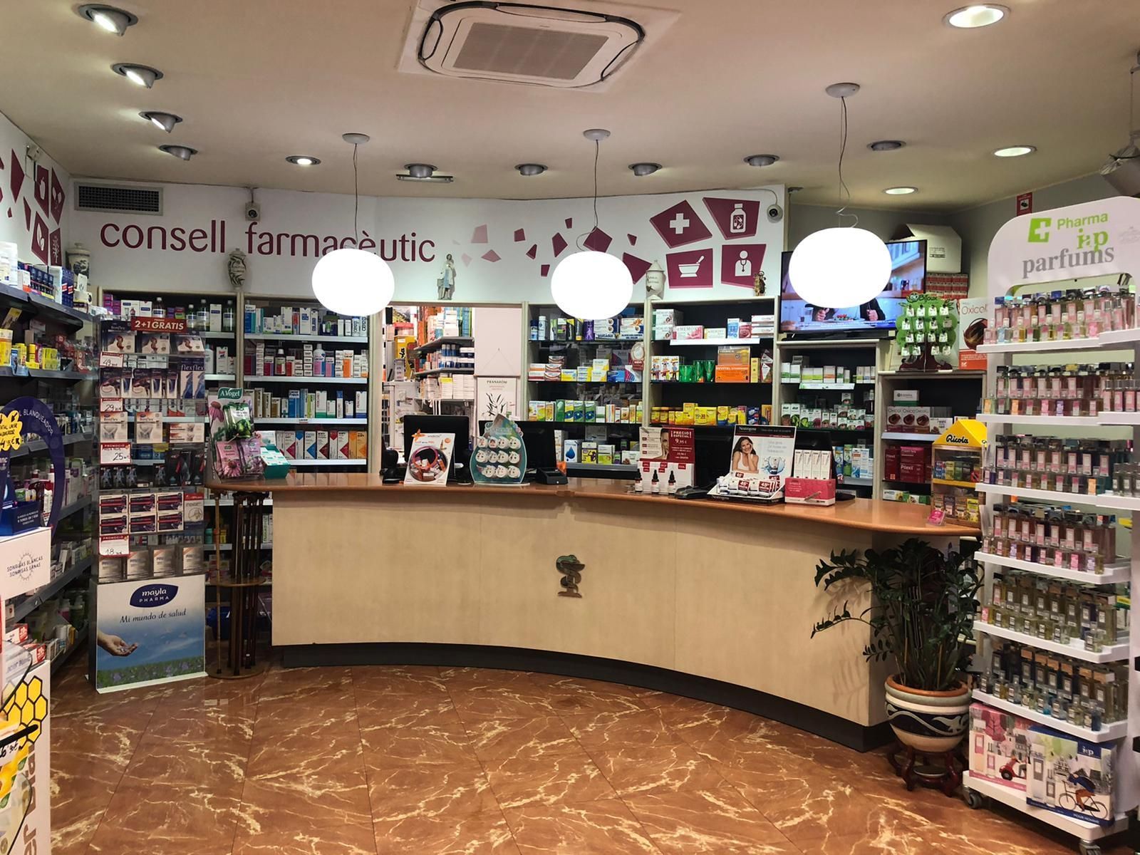 Una farmacia con muchos estantes y un mostrador.