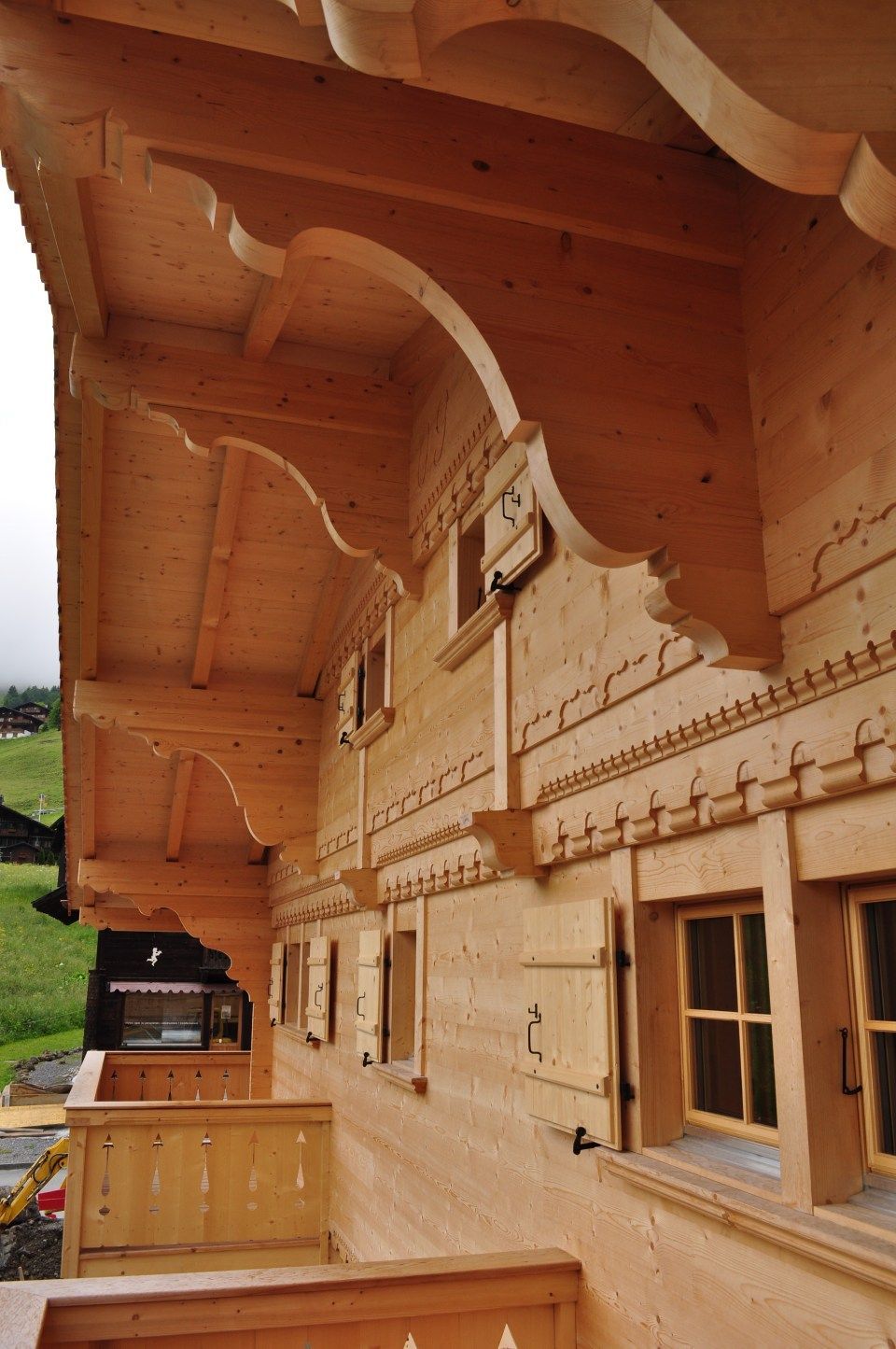 Une maison en bois avec un balcon et des volets aux fenêtres
