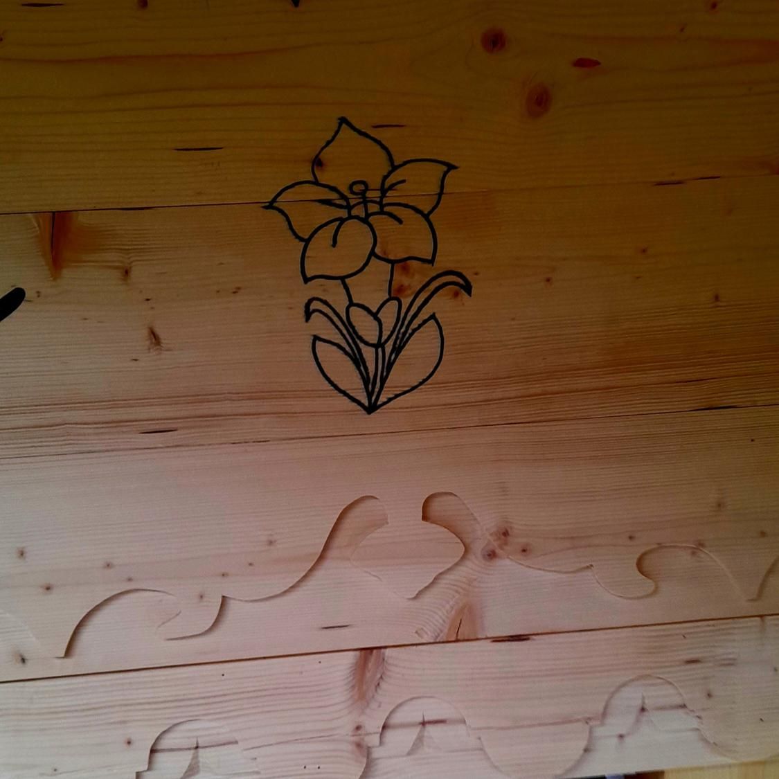 Un dessin d'une fleur sur une surface en bois