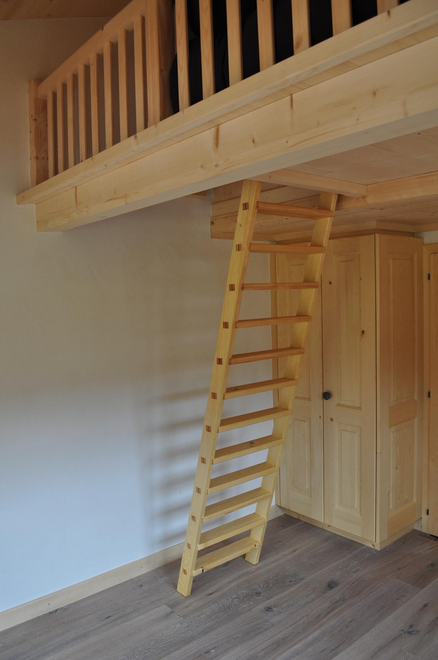 Une pièce vide avec un escalier en bois menant à un loft