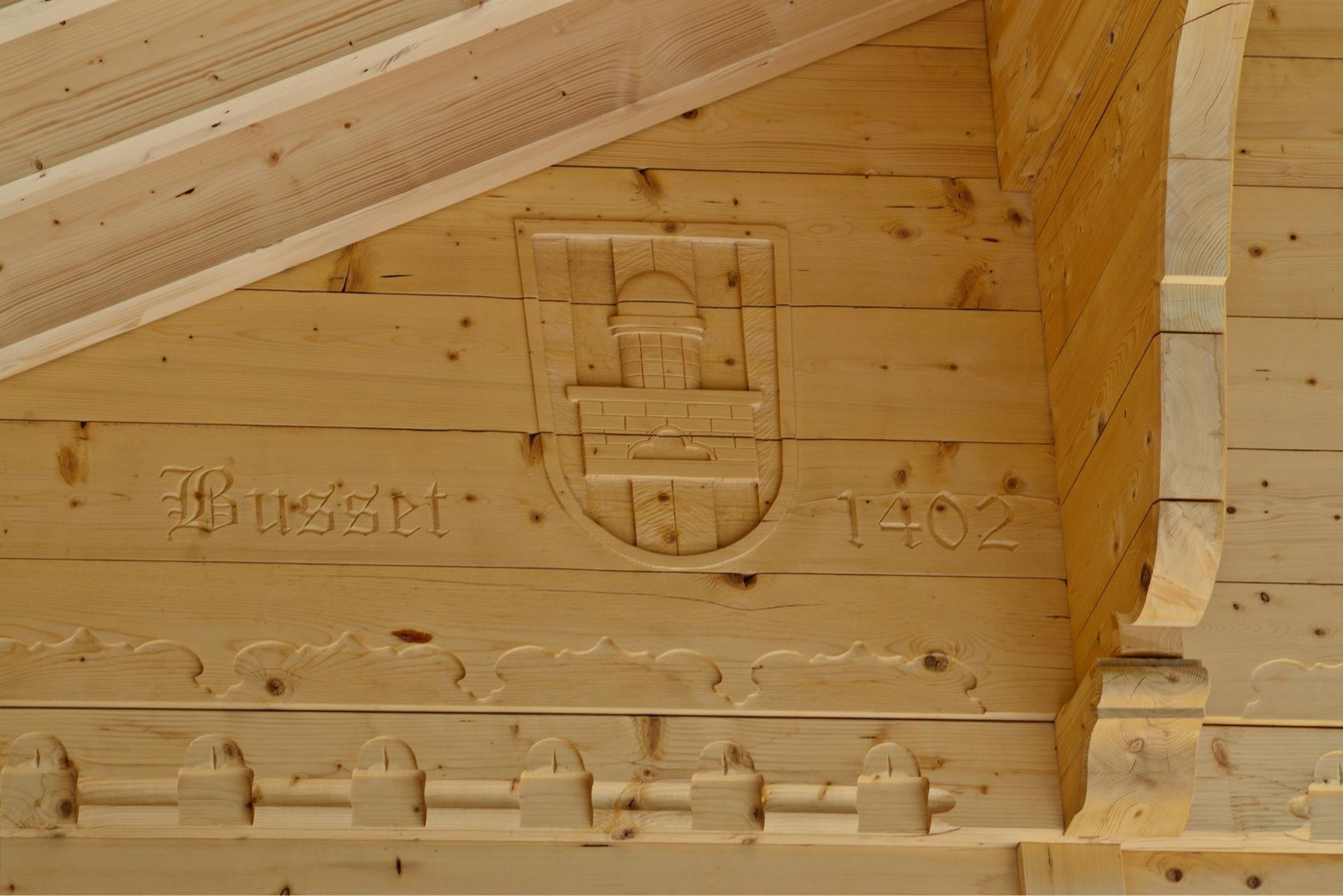 Un bâtiment en bois avec un blason sculpté dessus.
