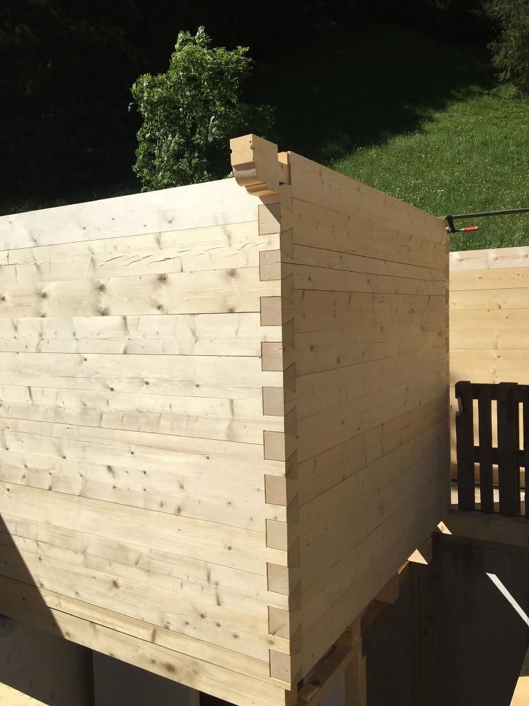 Un grand morceau de bois est en cours de construction avec une chaise en arrière-plan