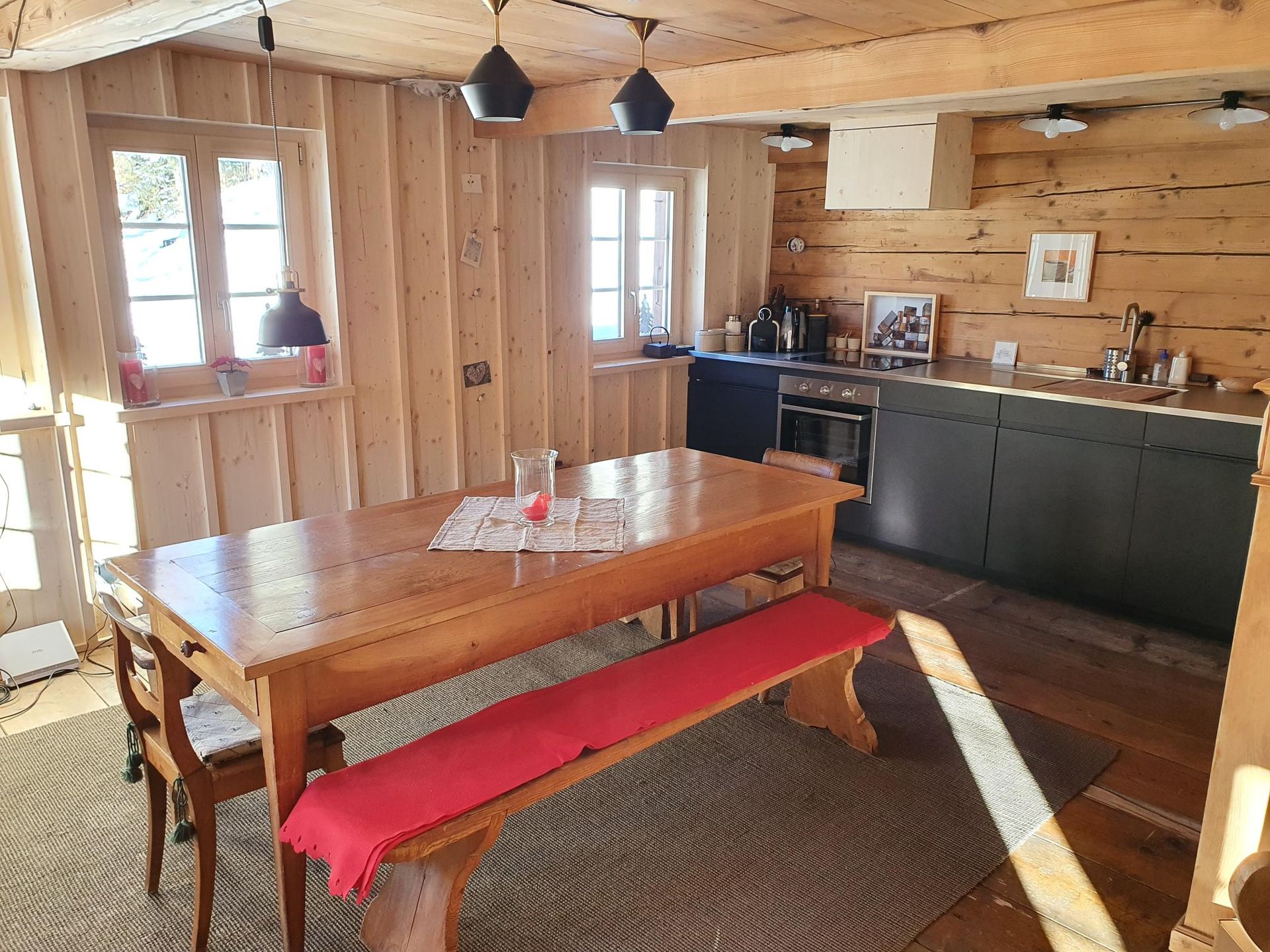 Une cuisine avec une table et un banc dedans