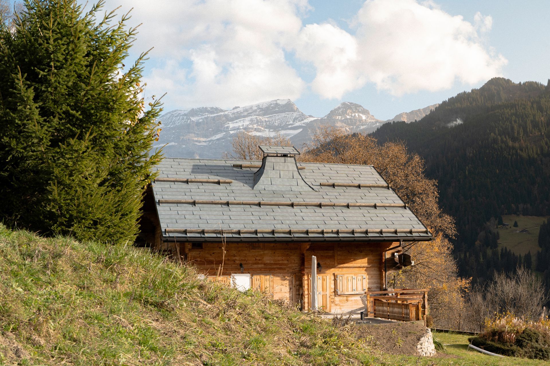 Une petite cabane dans les montagnes avec une montagne enneigée en arrière-plan