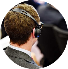 Un hombre con traje y corbata lleva auriculares.