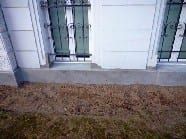 Lagenweise verdichtete Erdreichwiederverfüllung am sanierten Kelleraußenmauerwerk.