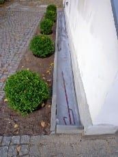 Wiederherstellung des Gehwegpflasters und der Bepflanzung. Herstellung einer Zierkiestraufe.