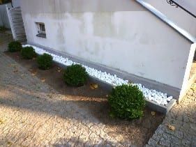 Wiederherstellung des Gehwegpflasters und der Bepflanzung. Herstellung einer Zierkiestraufe