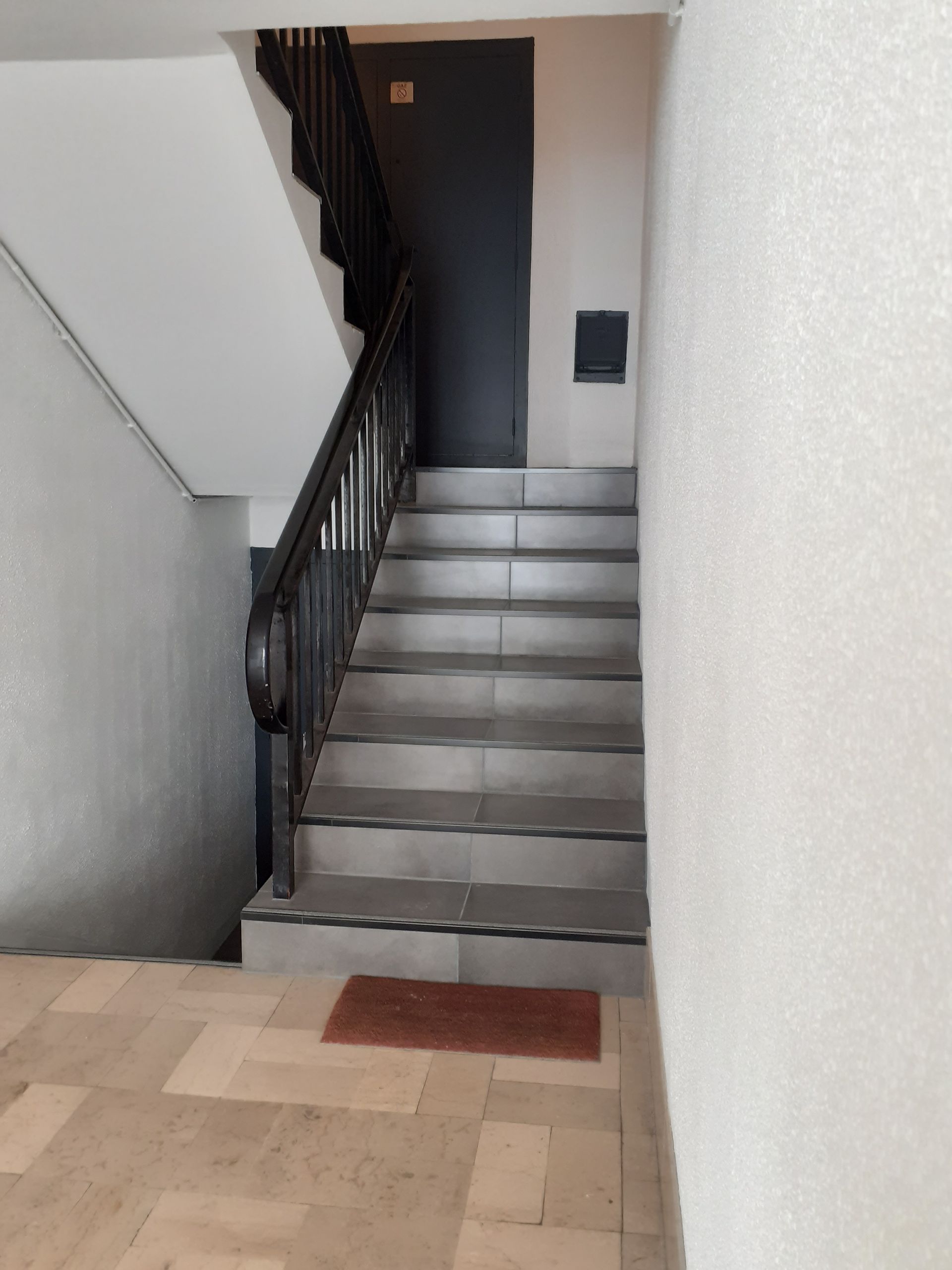 Peinture en blanc des murs d'une cage d'escalier d'immeuble