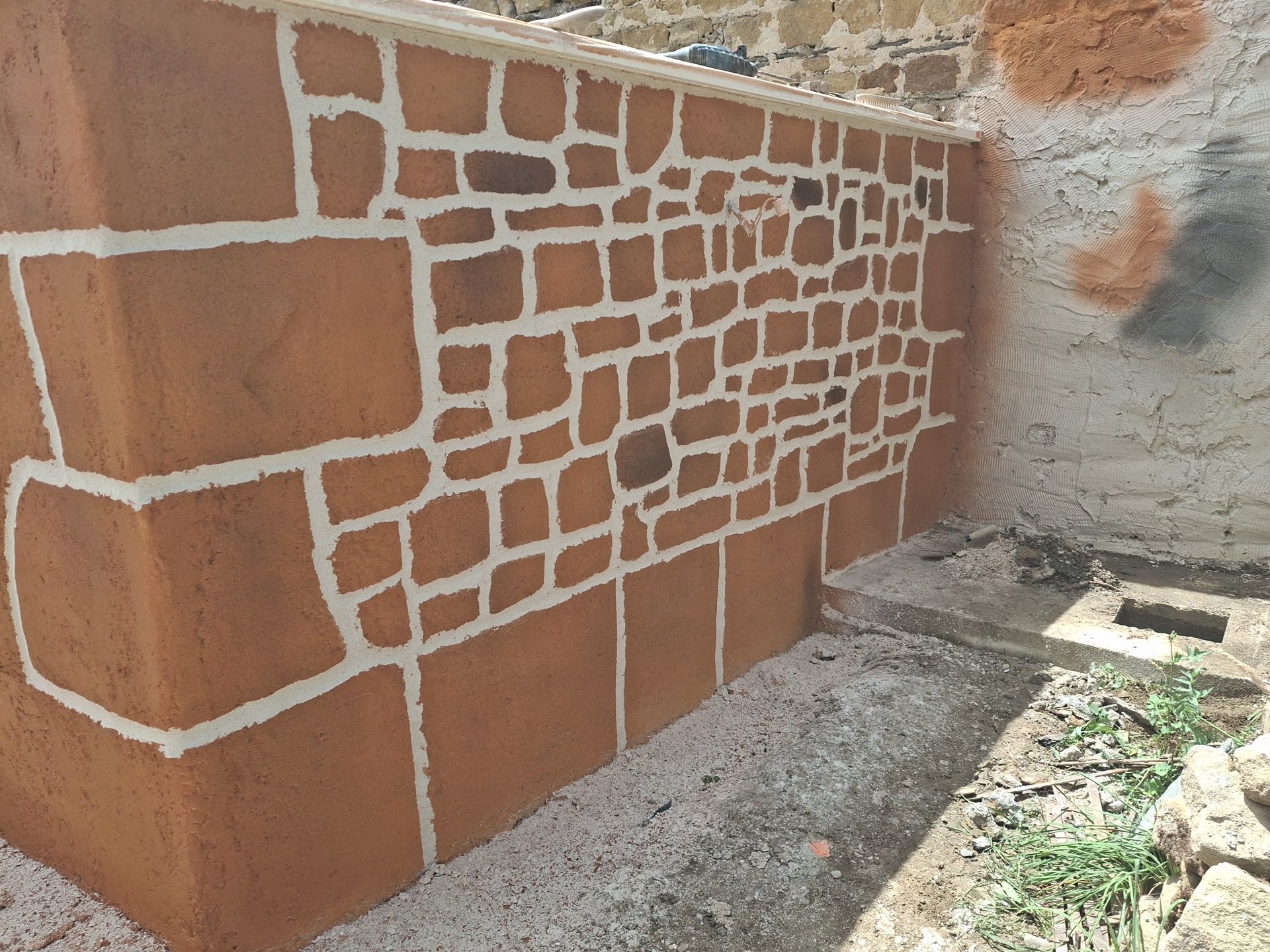 Peinture couleur brique sur un muret extérieur