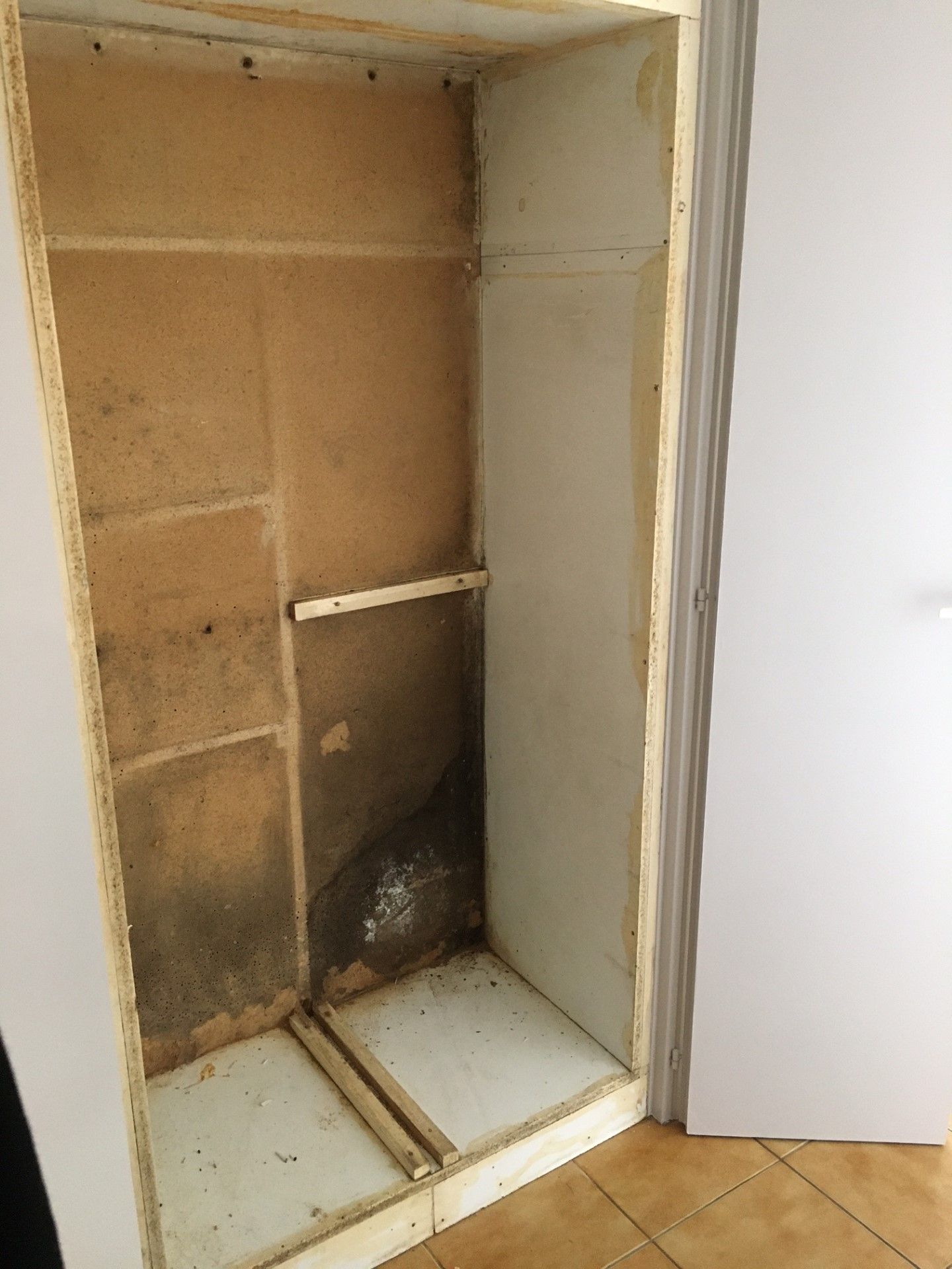 Un placard intégré dans un mur prêt à recevoir une étagère