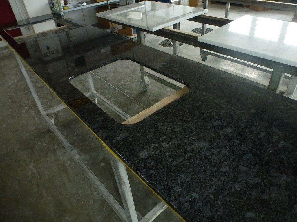 Eine schwarze Arbeitsplatte mit einem Waschbecken in der Mitte. Foto von der Hutter Natursteine AG