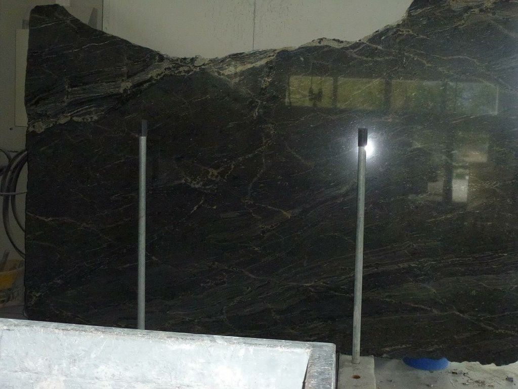 Ein grosses Stück schwarzer Granit liegt auf einem Tisch. Foto von der Hutter Natursteine AG