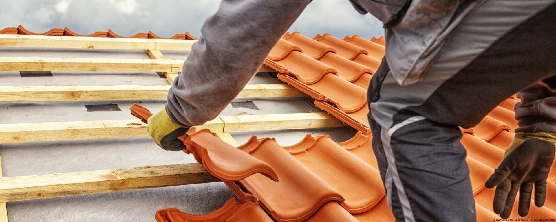 Dachdecker verlegt Dachziegel