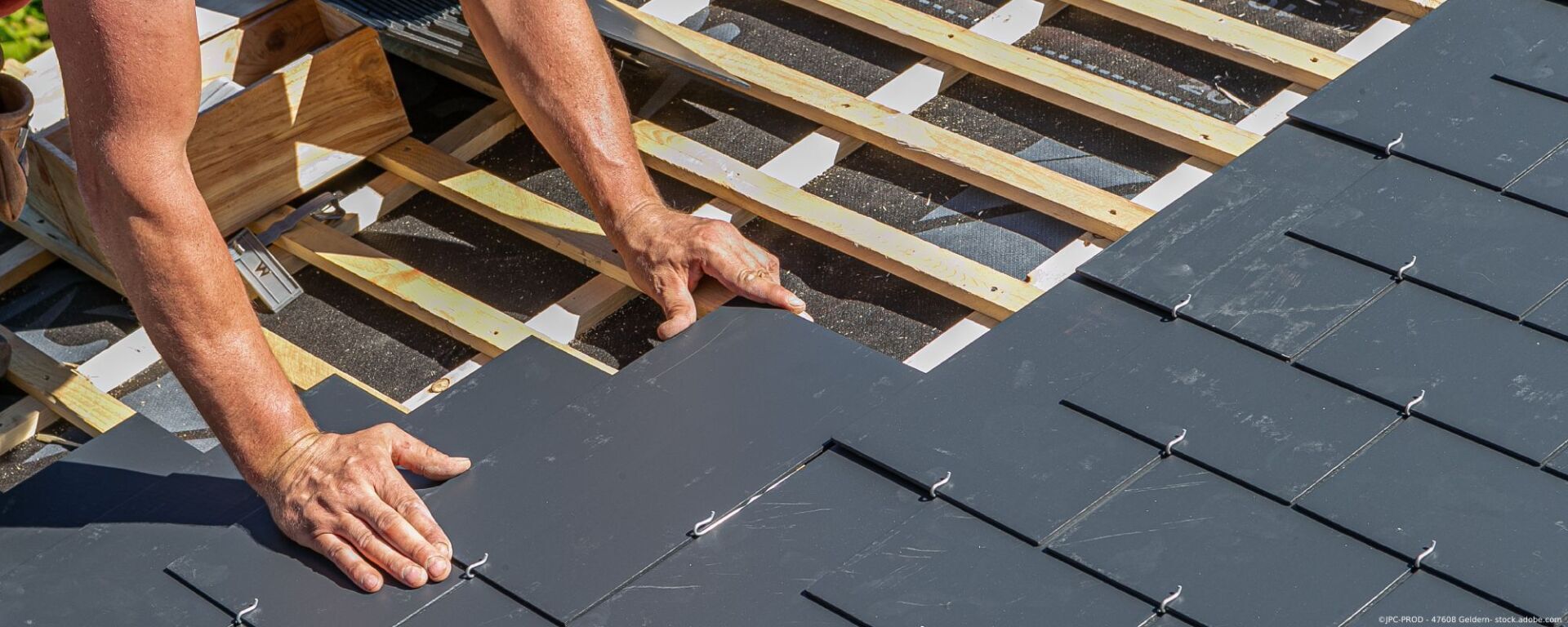 Dachdecker verlegt Schieferplatten