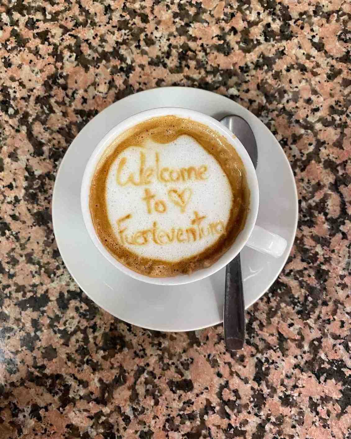 Taza de café con un dibujo de latte art que dice 