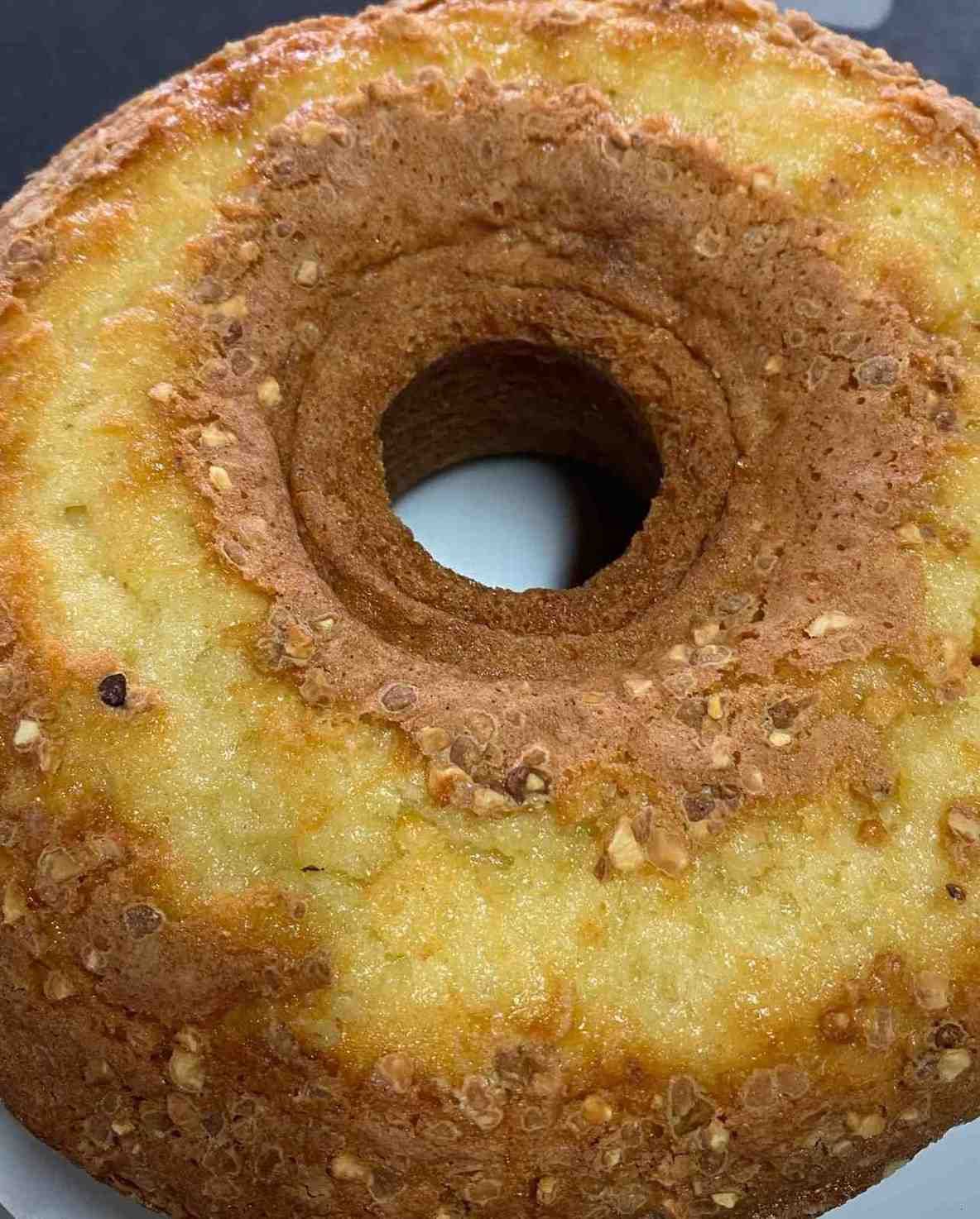 Primer plano de una rosquilla glaseada con un agujero central y una corteza azucarada de color marrón dorado.