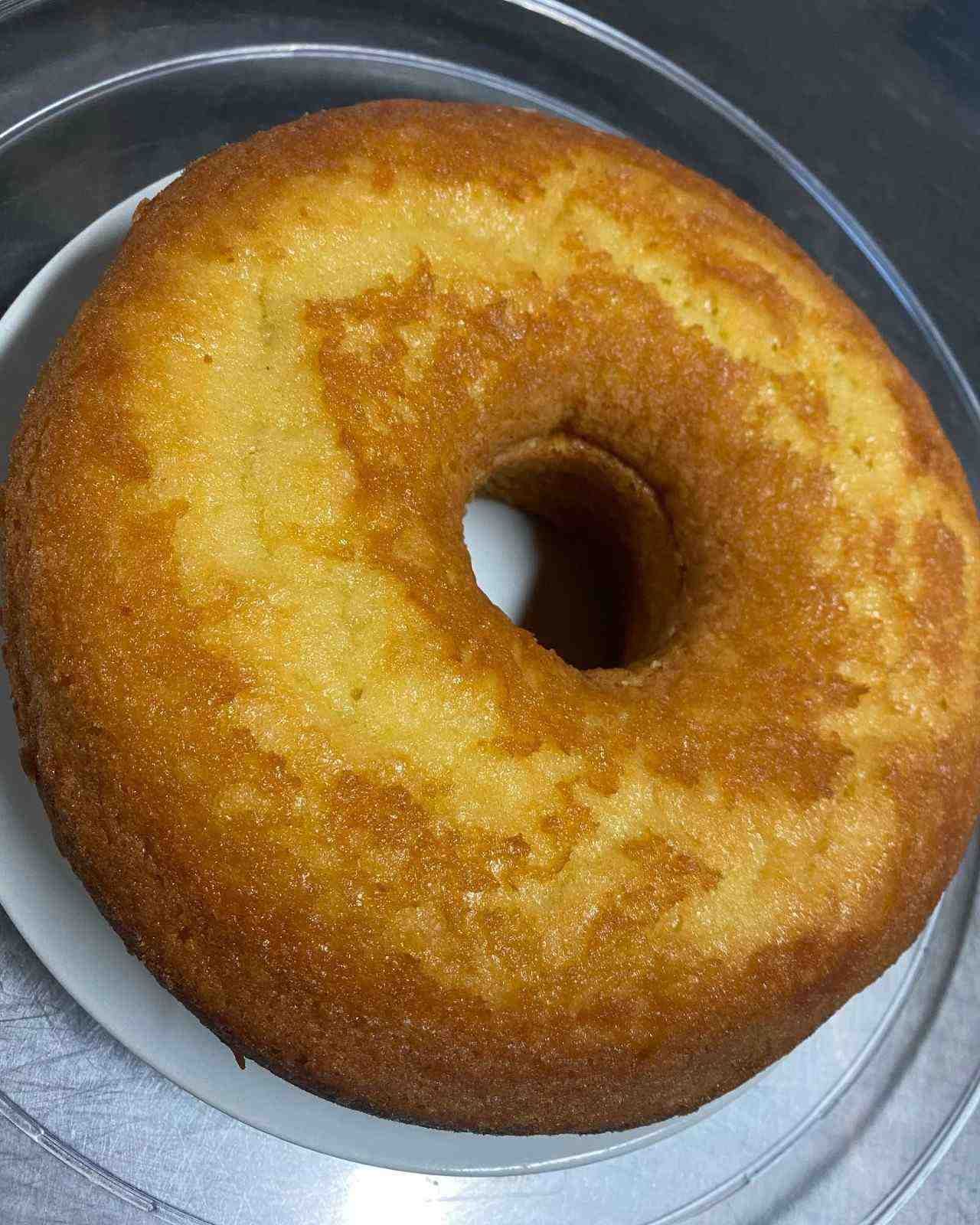 Pastel bundt glaseado dorado en un plato, visto desde arriba.