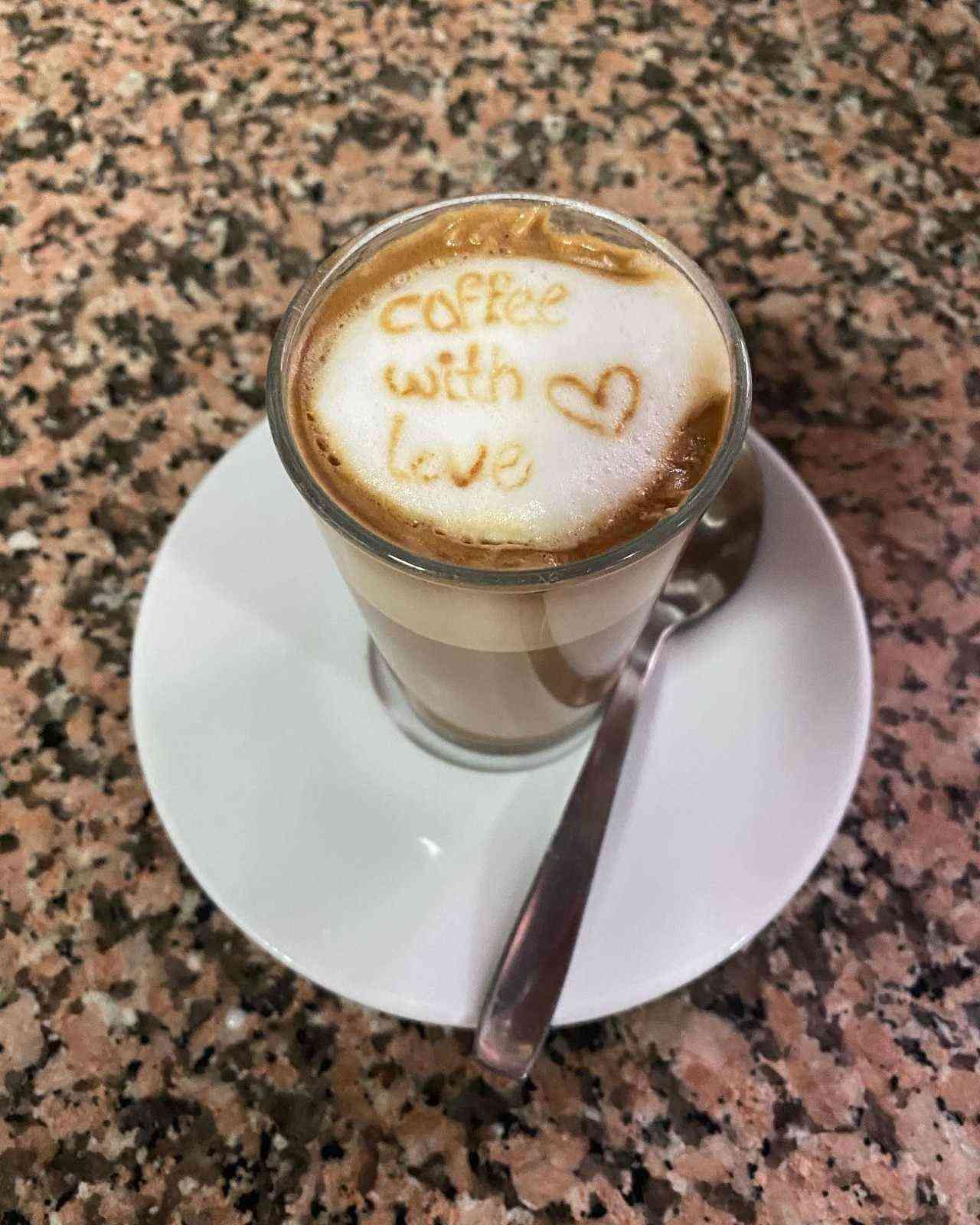 Un café con leche decorado con la frase 