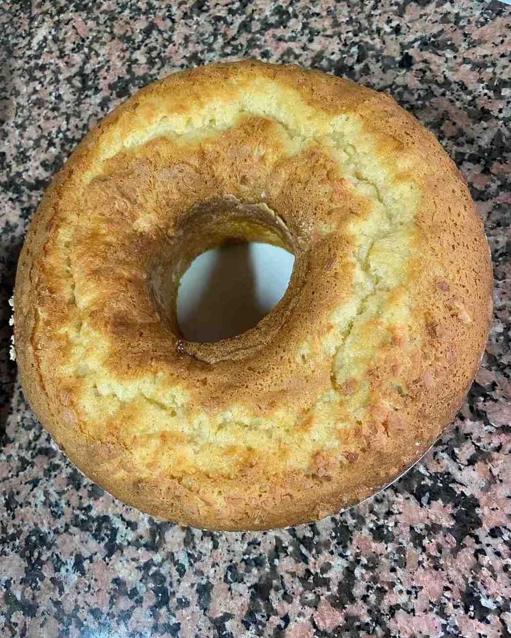 Pastel redondo de canela con un agujero en el centro sobre una encimera moteada.