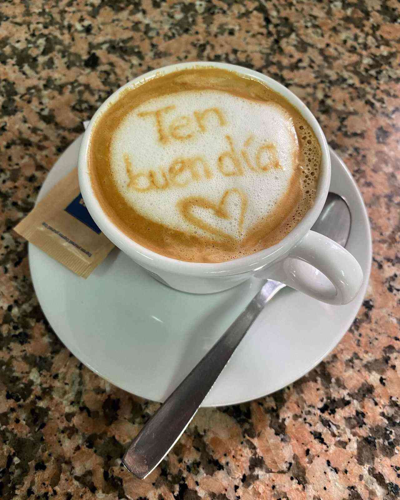 Taza de café con un dibujo de latte art que dice 