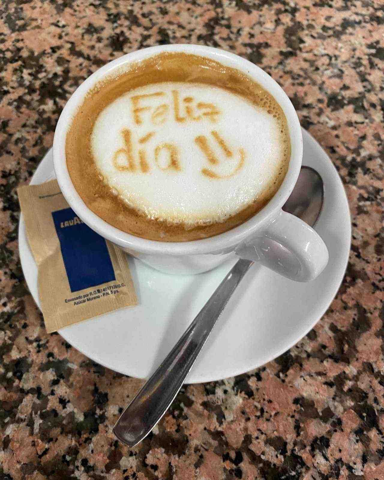 Taza de café con leche decorada con la frase 