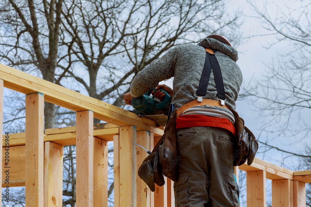 Un homme travaille sur une structure en bois.