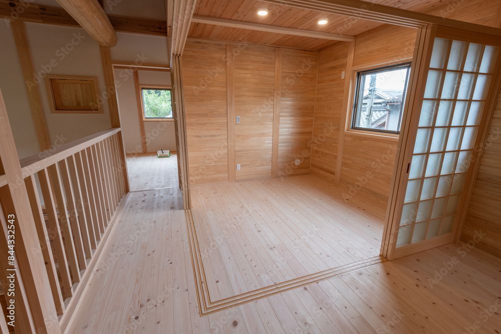 Une pièce vide dans une maison en bois avec une porte coulissante en verre.